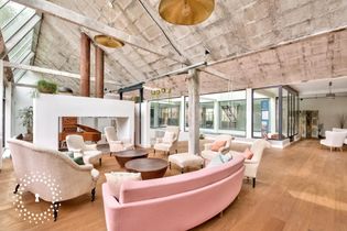 Lieux atypiques : loft vintage avec une grande pièce à vivre, des verrières et une décoration aux tons rosés.